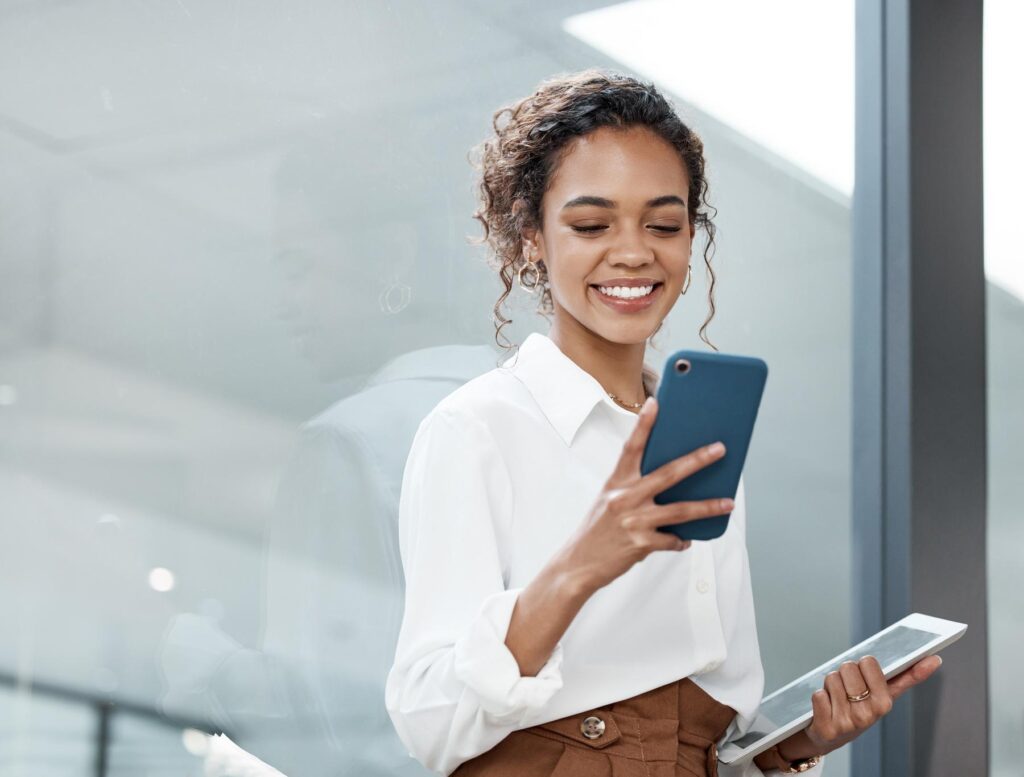 Professional woman and tablet with mobile phone at a company is typing a conversation on the internet. Female person, business and communication with tech for entrepreneurship at the office.