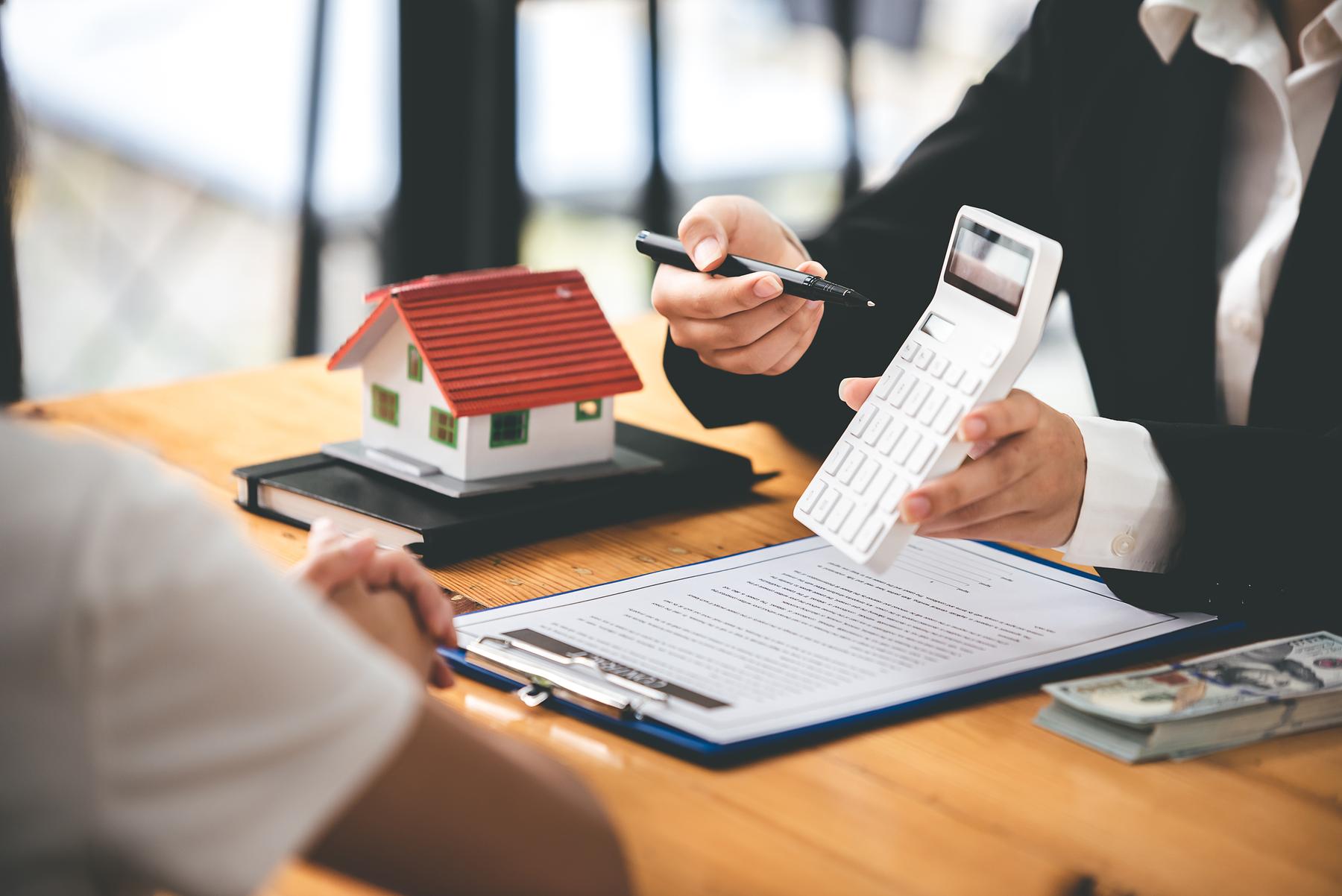 A real estate agent in a black suit discussing property taxes with a tenant.