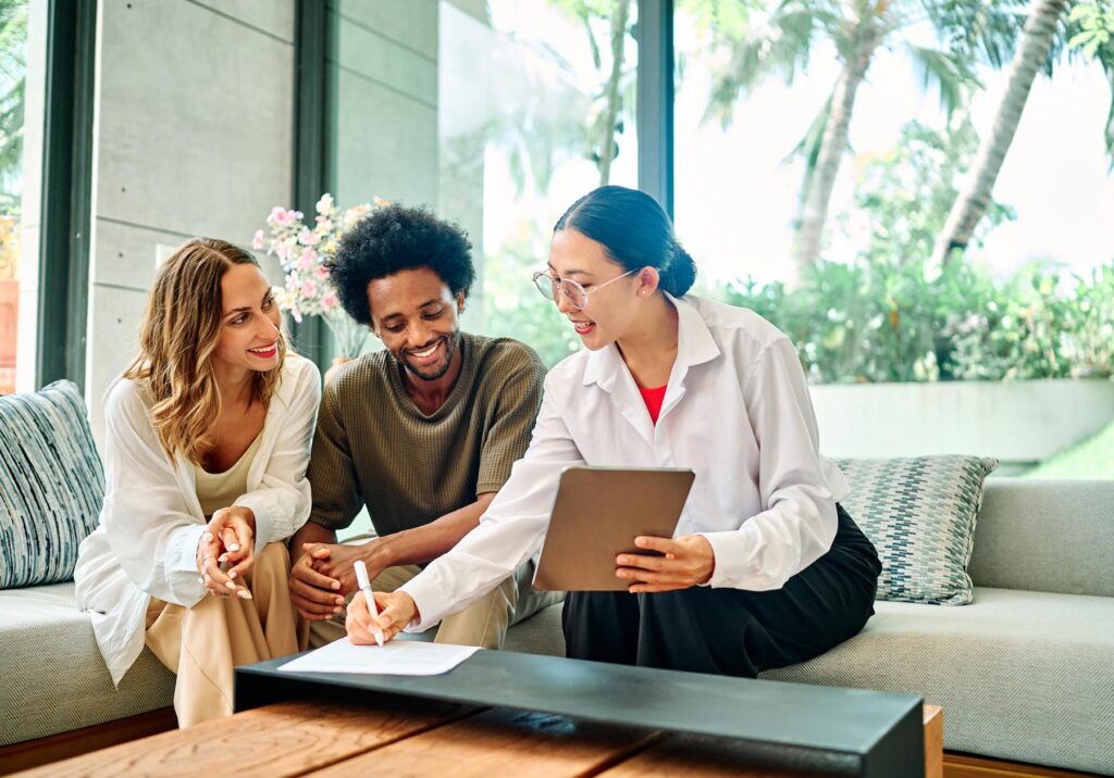 three people sitting on a couch discussing real estate investments