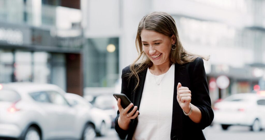 Business woman, phone and celebration in city, excited or notification for good news on commute. Person, smartphone and achievement with job promotion, goals and success with mobile app in Australia