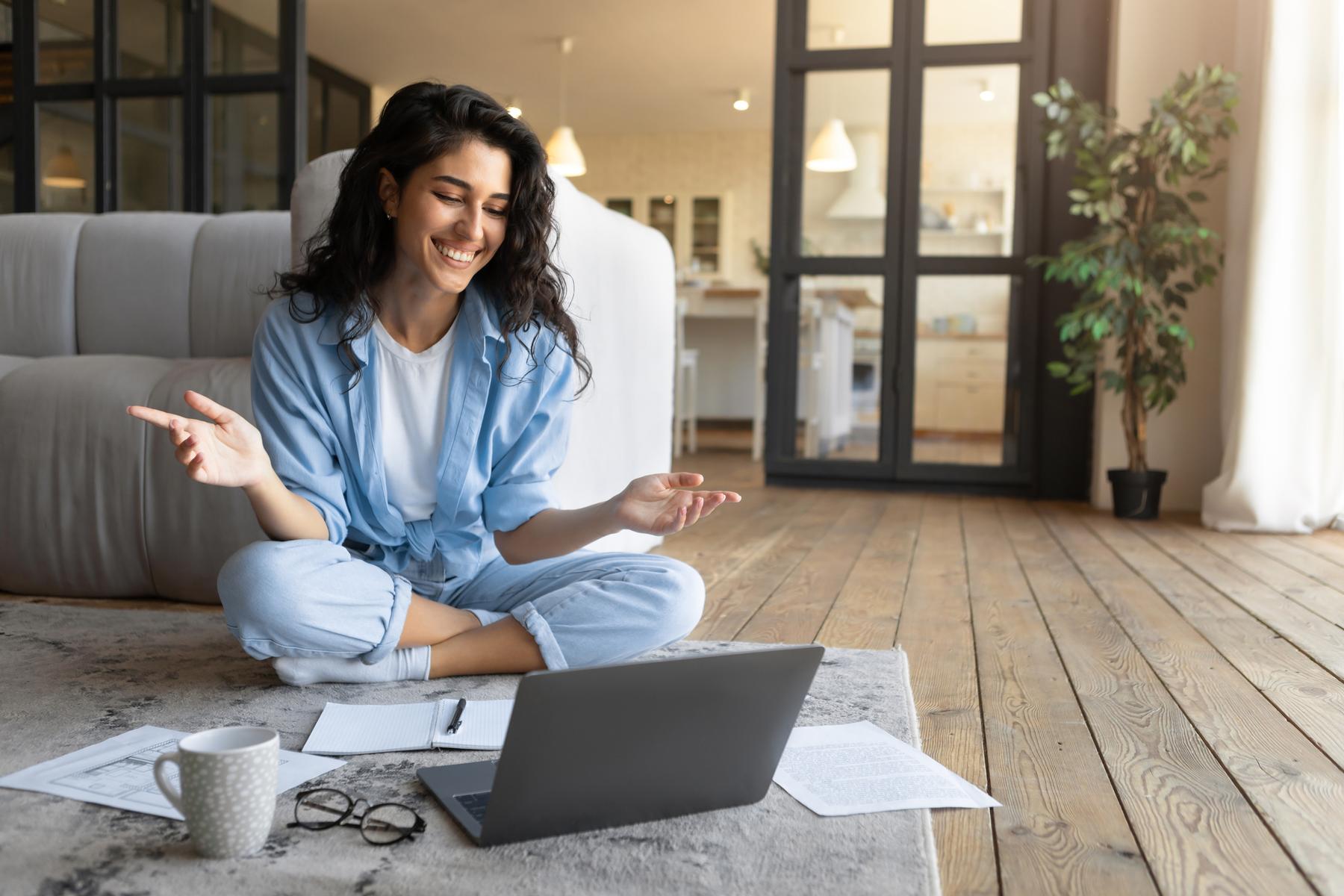 Portrait of cheerful young woman making video call, using laptop, communicating online from home, copy space