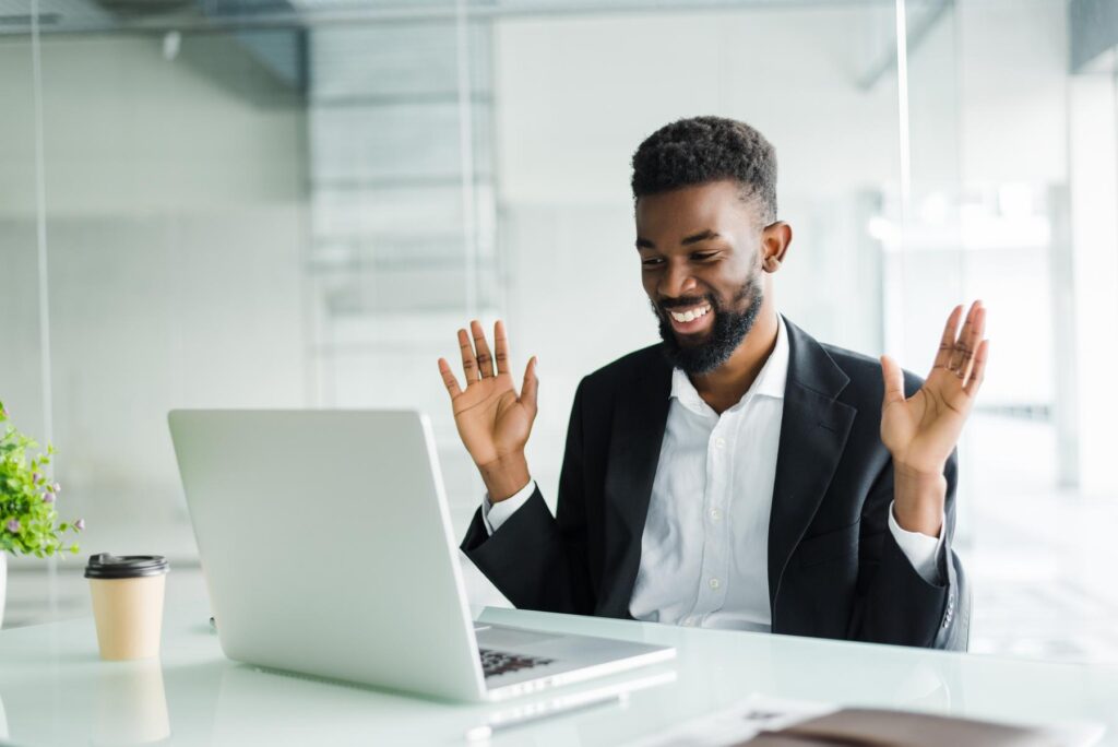 Shocked african american businessman in suit feeling stunned by online news looking at computer screen sitting at workplace with laptop, stressed trader investor surprised by stock market changes