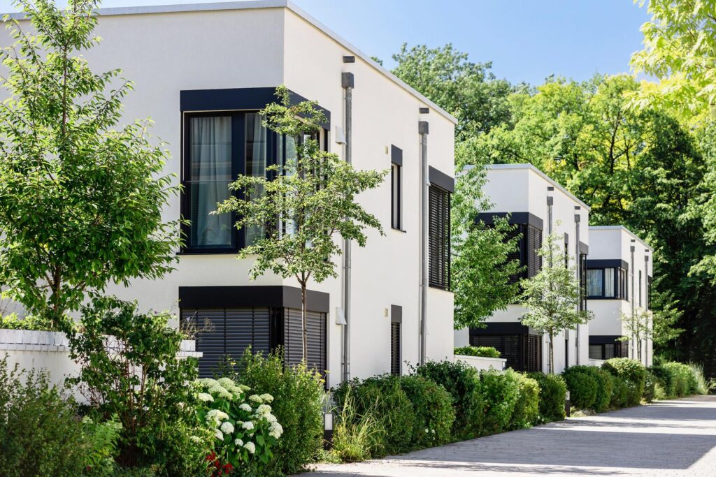 Modern Apartment Building in Green City. Low rise Residential Buildings with Modern Exterior Design White Facade, Flat roof and Landscaping. Contemporary Facade Building in Germany.