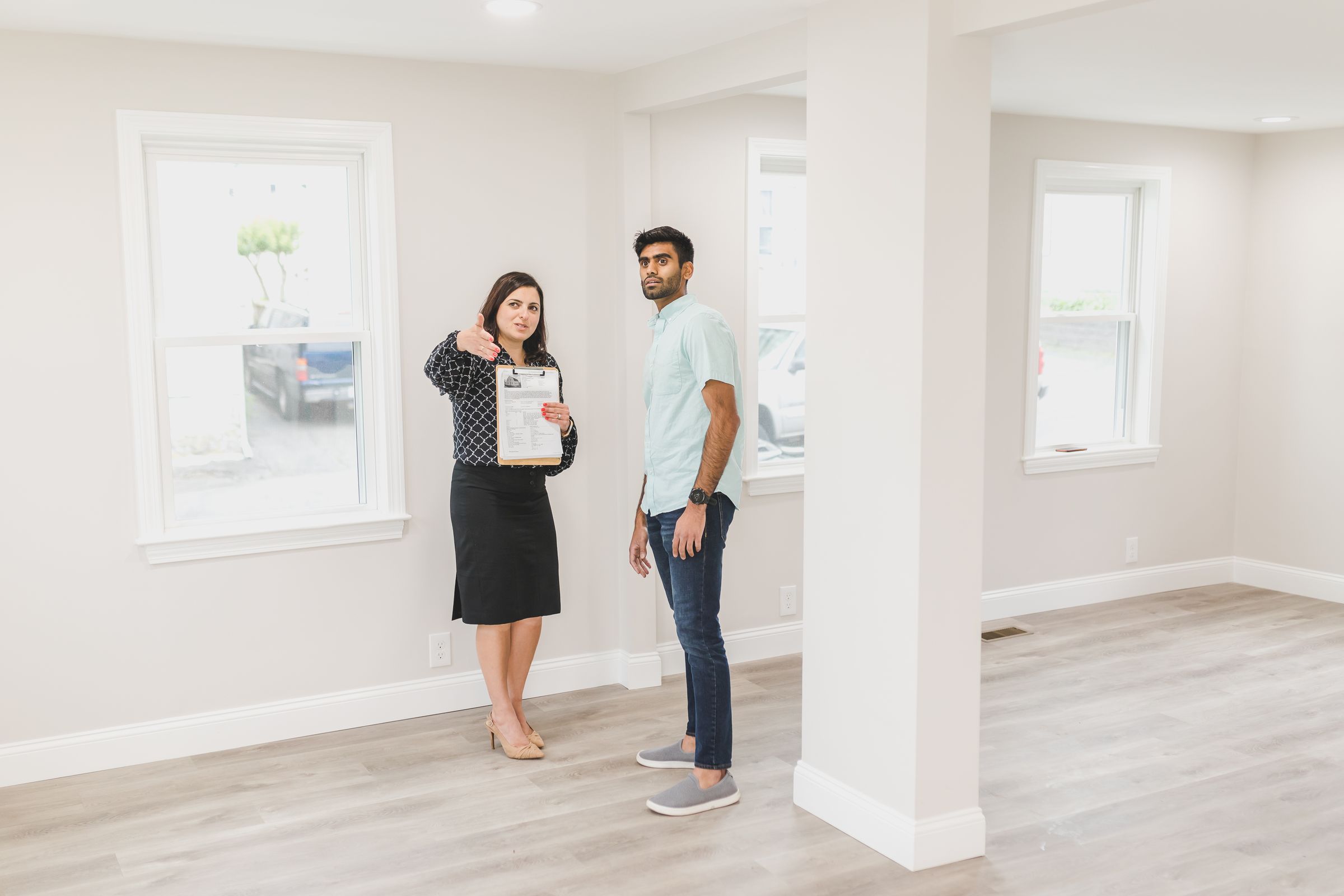 A licensed property manager showing a potential customer the interior of a new home.