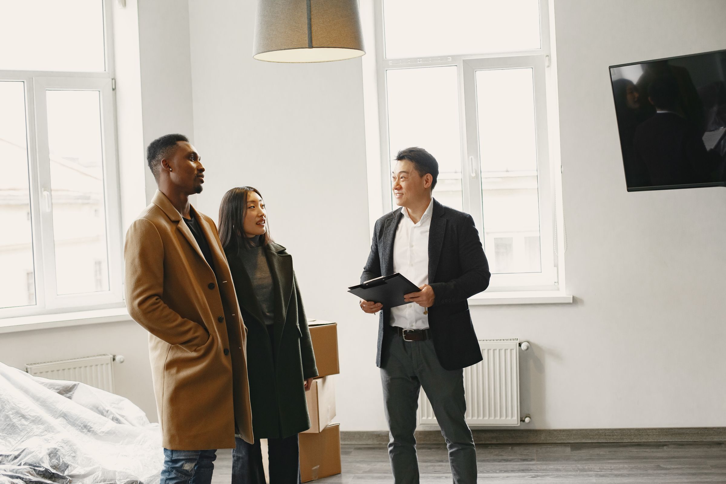 Licensed property manager discussing property details with a couple in a modern room.