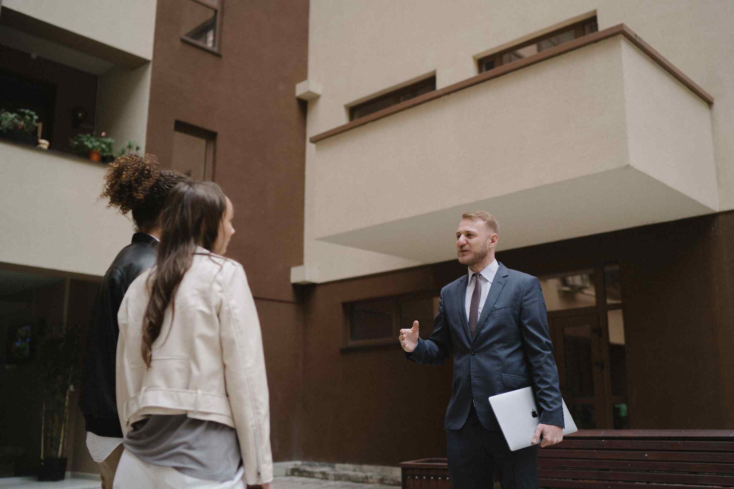 A licensed property manager shows an apartment to a couple, illustrating a property tour experience.