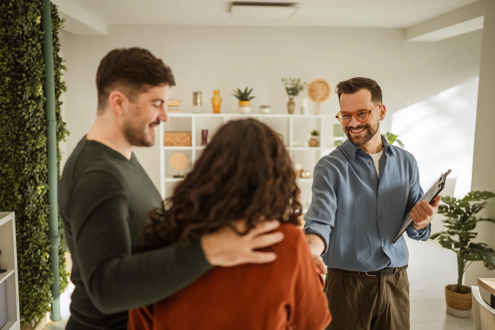 A property manager in Kentucky shaking hands with a couple.