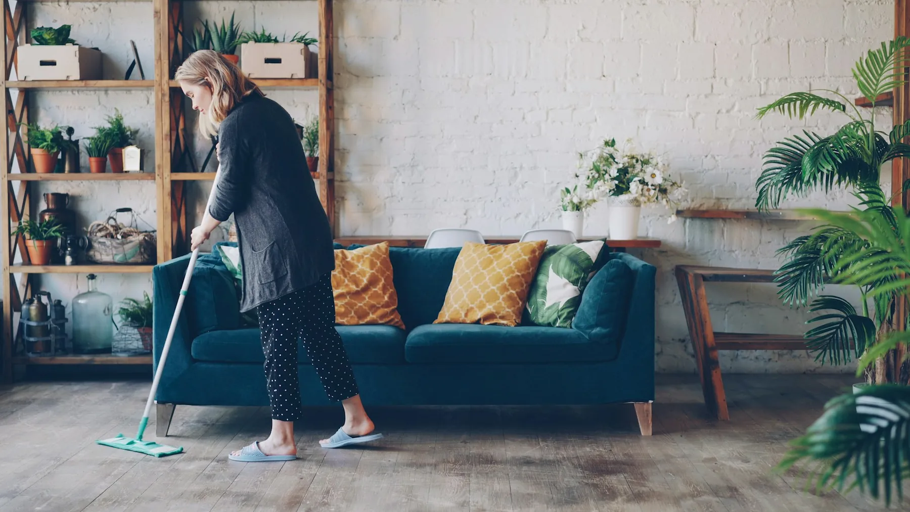 Woman cleaning the floor in a modern living room.