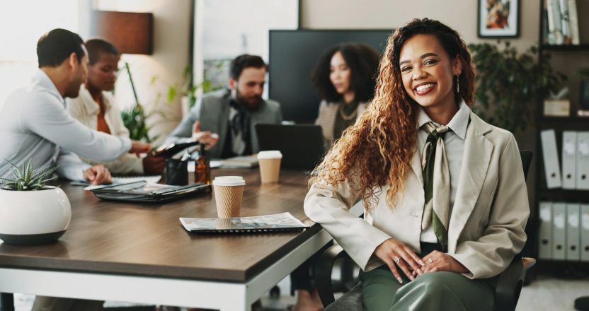 Collaboration, portrait and smile of business woman in boardroom with colleagues for planning. Corporate, face and meeting with happy African employee in professional workplace for career development