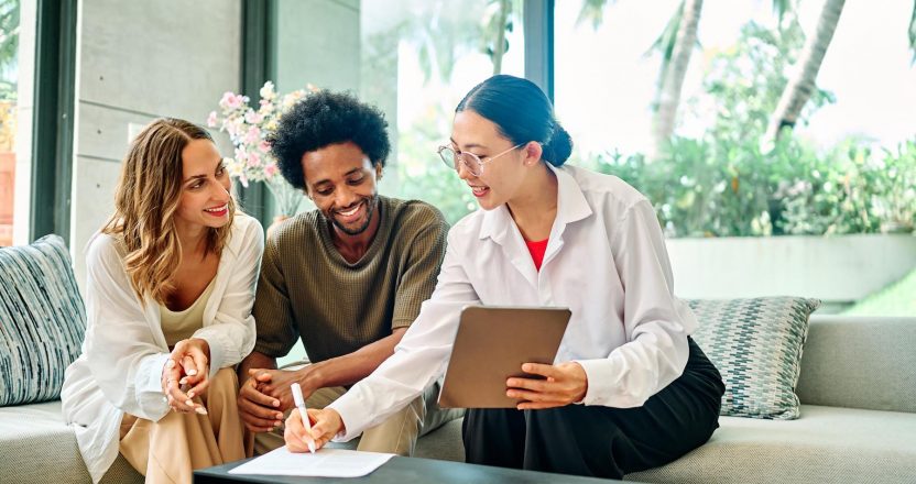 three people sitting on a couch discussing real estate investments