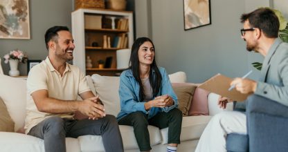Happy couple talking with financial advisor at home