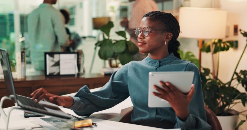 Happy, tablet and woman with laptop, office and media strategist with info, typing and digital marketing. Online, smile and research for target audience, planning and person with tech in business