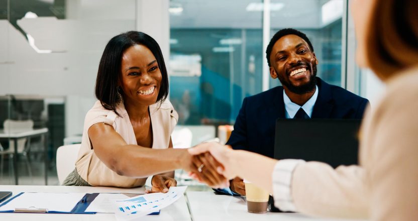 Business partners shaking hands after successful meeting in modern office