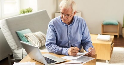 Senior Man Filing Tax Report at Home