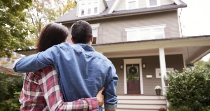 Rear View Of Loving Couple Looking At House