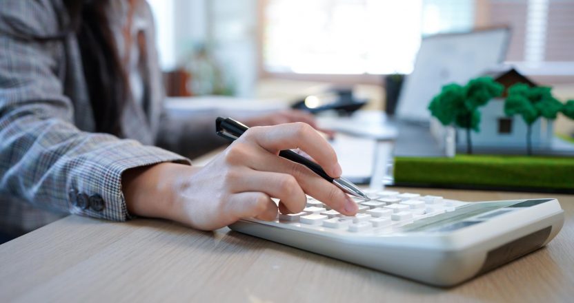 Business mortgage realtor with house model, sitting at desk, real estate agent manager working on calculator and documents, mortgage and property