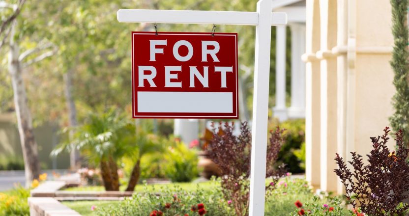 Red For Rent Real Estate Sign in Front House.