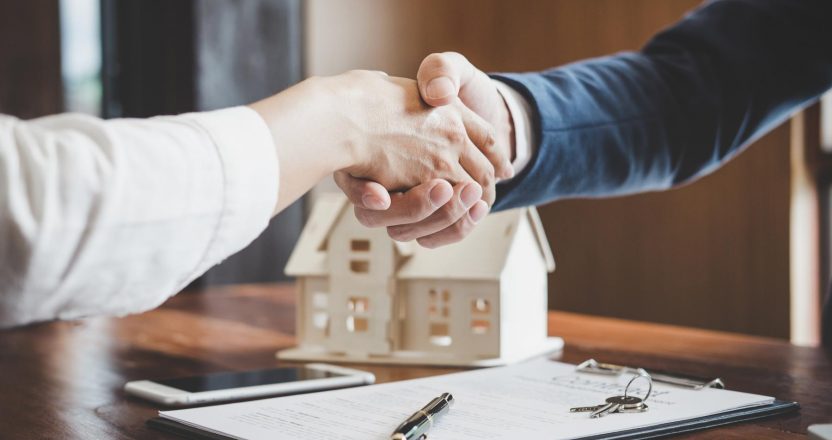 Real estate agent and customers shaking hands together celebrati