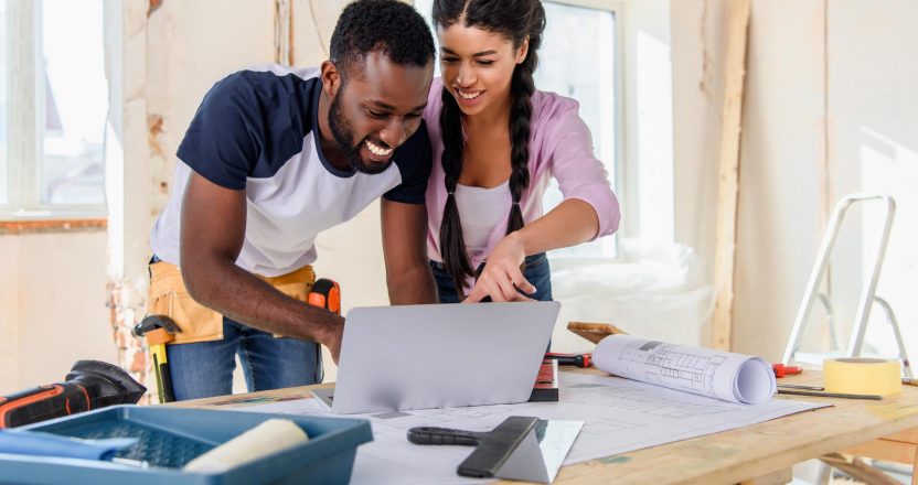 Young african american woman pointing at laptop screen to boyfri
