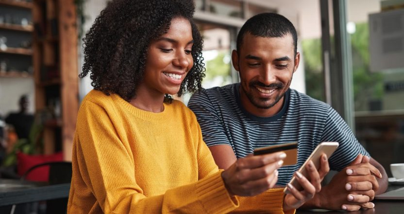 Man looking at his girlfriend shopping online in cafe