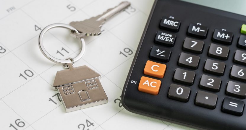 New house purchase, mortgage schedule reminder or real estate payment day, silver house keyring with calculator on white clean calendar