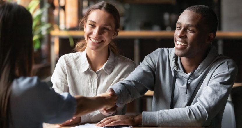 Happy interracial couple handshake bank manager take mortgage loan