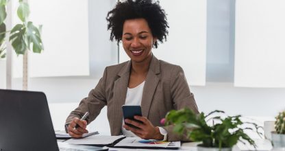Happy smiling african-american business woman working on laptop
