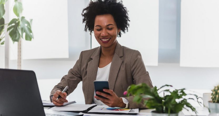 Happy smiling african-american business woman working on laptop