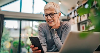 Portrait of a cheerful senior businesswoman using smart phone at