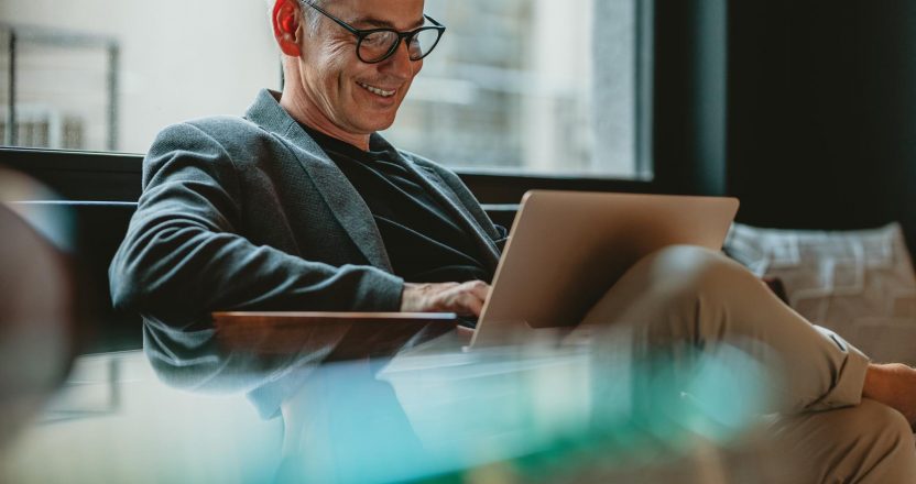 Business professional working on laptop in office lobby