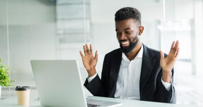Shocked african american businessman in suit feeling stunned by online news looking at computer screen sitting at workplace with laptop, stressed trader investor surprised by stock market changes