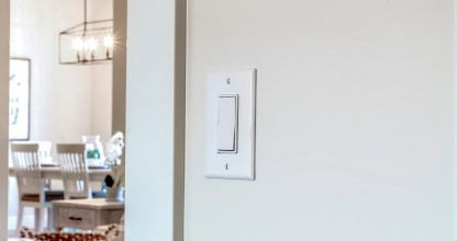 Wall mounted electrical rocker light switch with blurry dining room background
