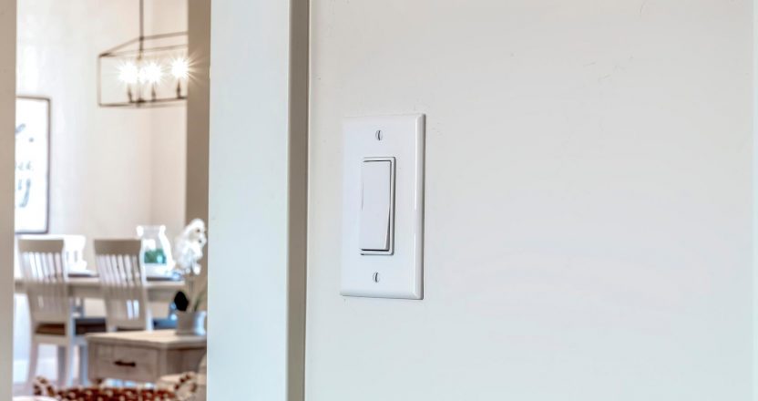 Wall mounted electrical rocker light switch with blurry dining room background