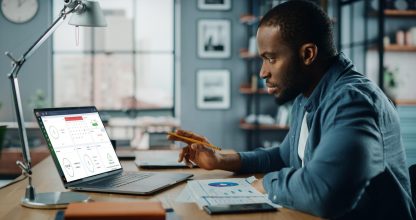 Handsome Black African American Specialist Working on Laptop Com
