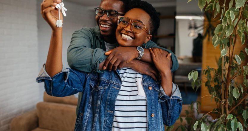 Couple cheerful home owners holding a key