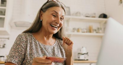 Close up indoor portrait of excited grey haired woman satisfied