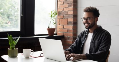 Young man student using laptop computer at home, studying online