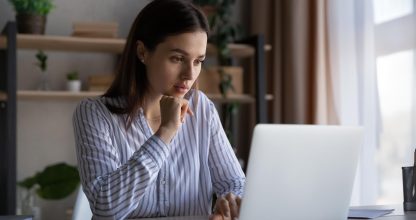 Thoughtful focused student girl working at laptop from home