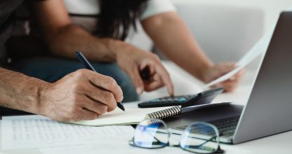 Man and woman are calculating annual tax with calculator and fil