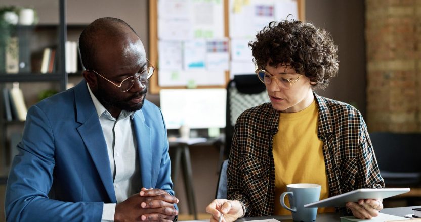 A guarantor talking to a woman on a desk.