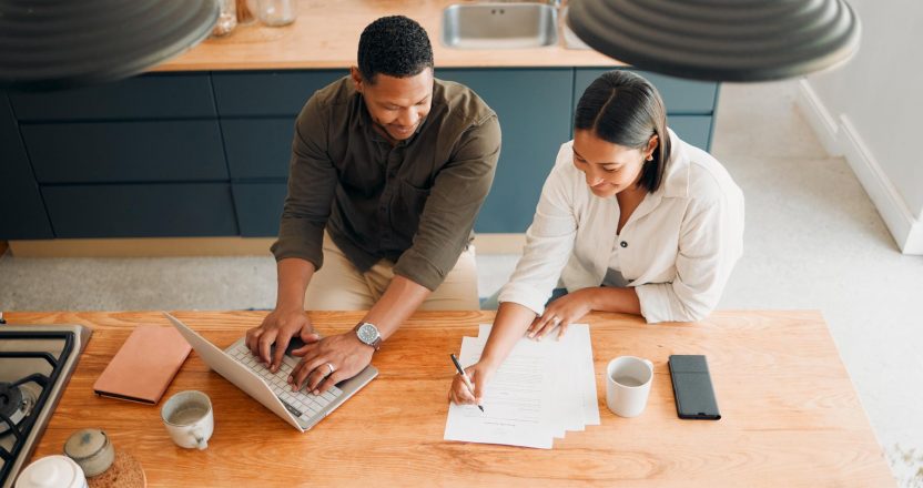 Couple calculating budget, finance and tax while planning investment, loan and bills at home from above. Managing household spending, saving and account to pay money with online banking for insurance