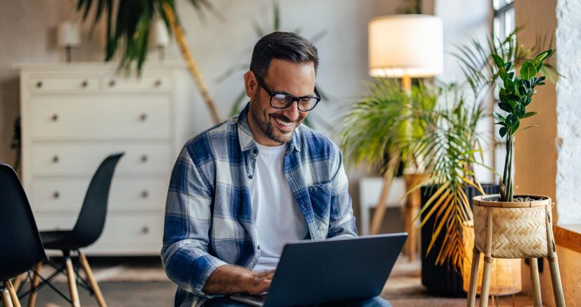 Smiling businessman working at the co-working space, sitting wit