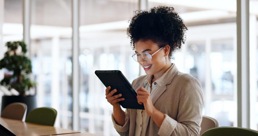 A property manager checks a tenant's rental history on a tablet in a bright office.