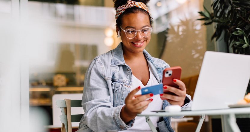 Woman smiling and using mobile for online payment