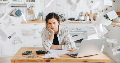 Stressed woman trying to deal with financial documents, having problem to find money to pay utility bills or loans. Receipts and bills rain down on the head. Advertising mockup for accounting company
