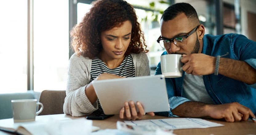 Tablet, news or couple with financial budget, investment growth or planning savings online on website. Coffee, interest rates or people reading on recession for bills, inflation or household expenses
