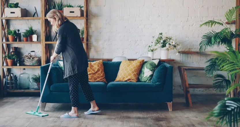 Woman cleaning the floor in a modern living room.