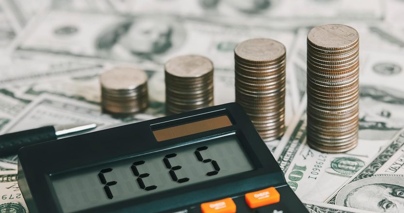 Calculator with the word FEES on the calculator placed on the dollar, concepts, fees, fees services and taxes.