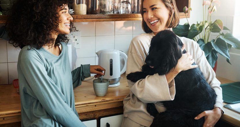 Happy, dog and morning with lesbian couple in kitchen for relax, support and care. Canine animal, love and smile with gay women and pet puppy at home for bonding, playful and happiness together