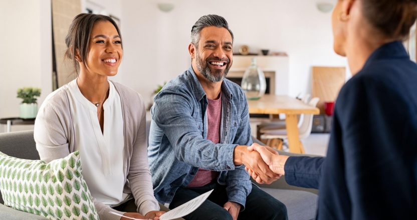 Multiethnic couple handshake with consultant at home